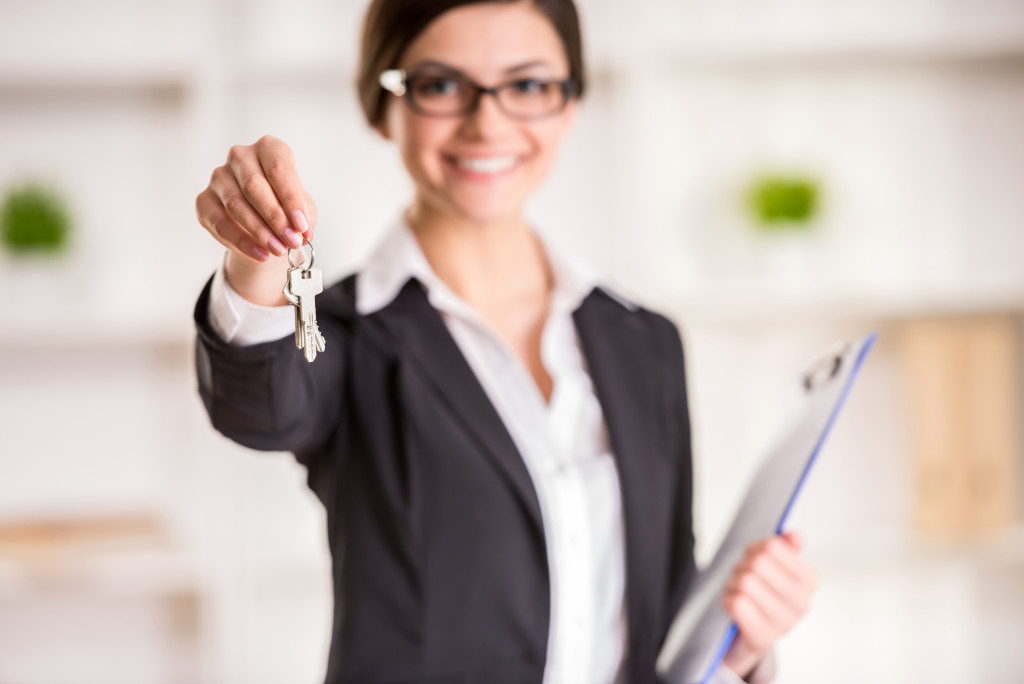 woman holding keys and a clipboard