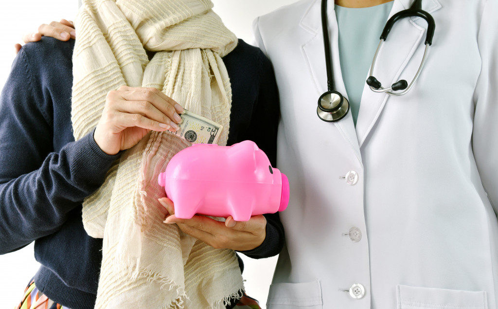 a person and a doctor holding a piggybank
