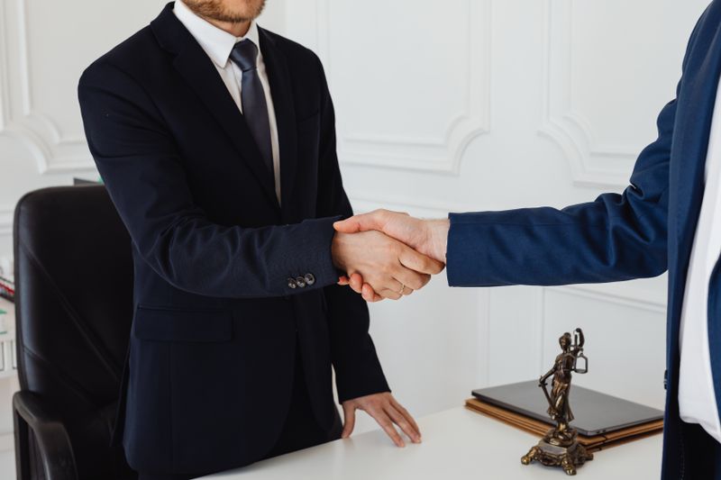 a lawyer and a client doing a handshake